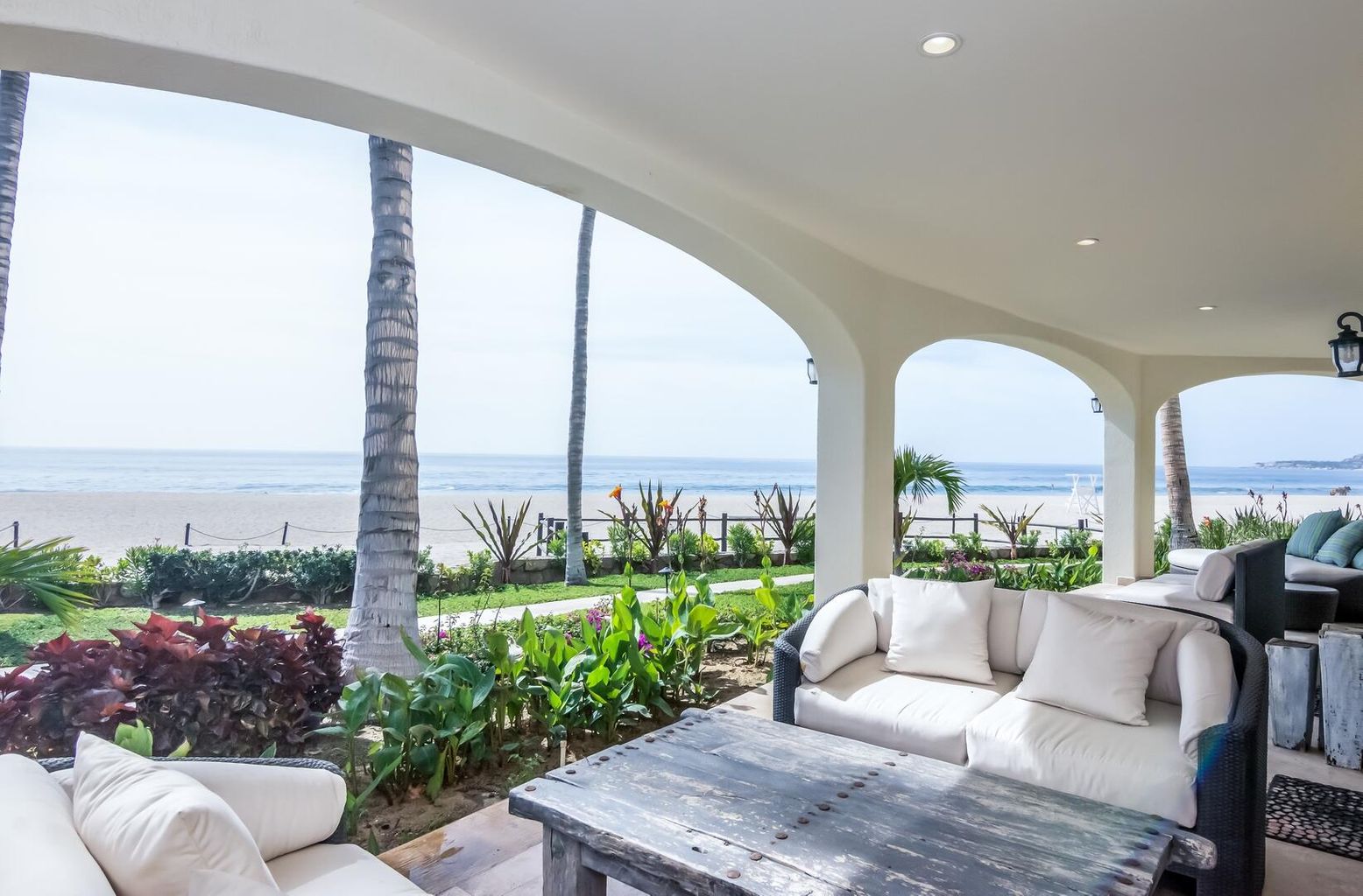 Covered terrace overlooking palm gardens and the ocean